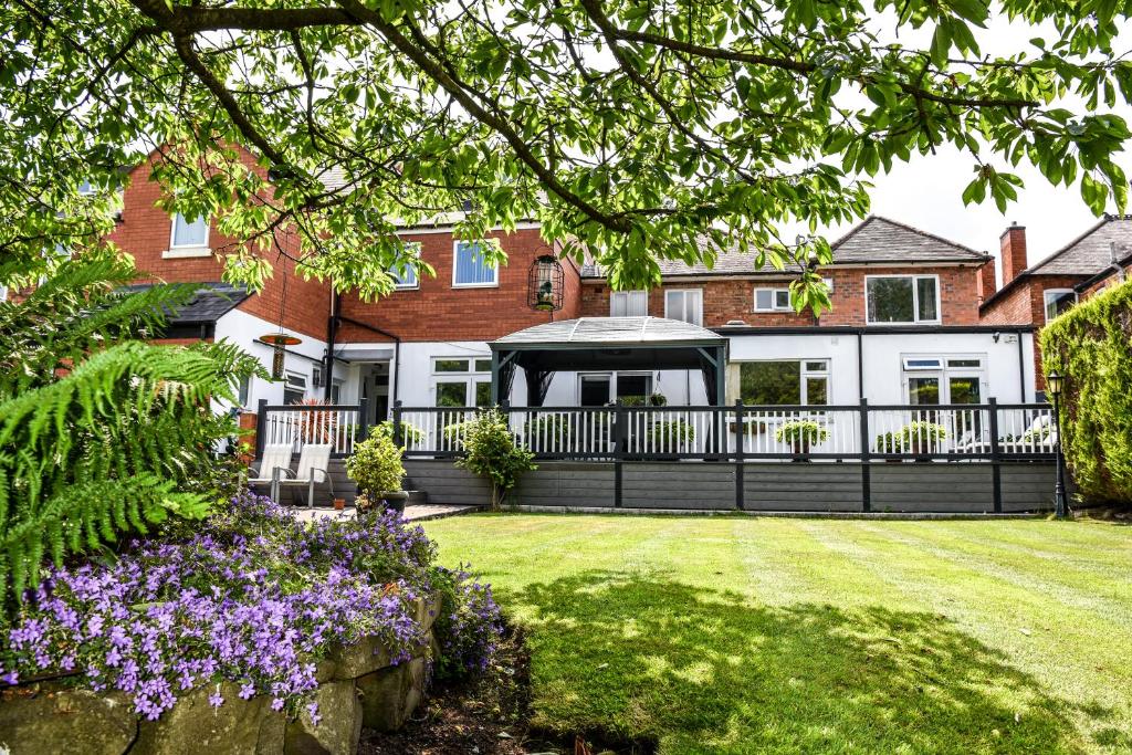 une maison avec une clôture noire et des fleurs violettes dans l'établissement Maryland, à Derby