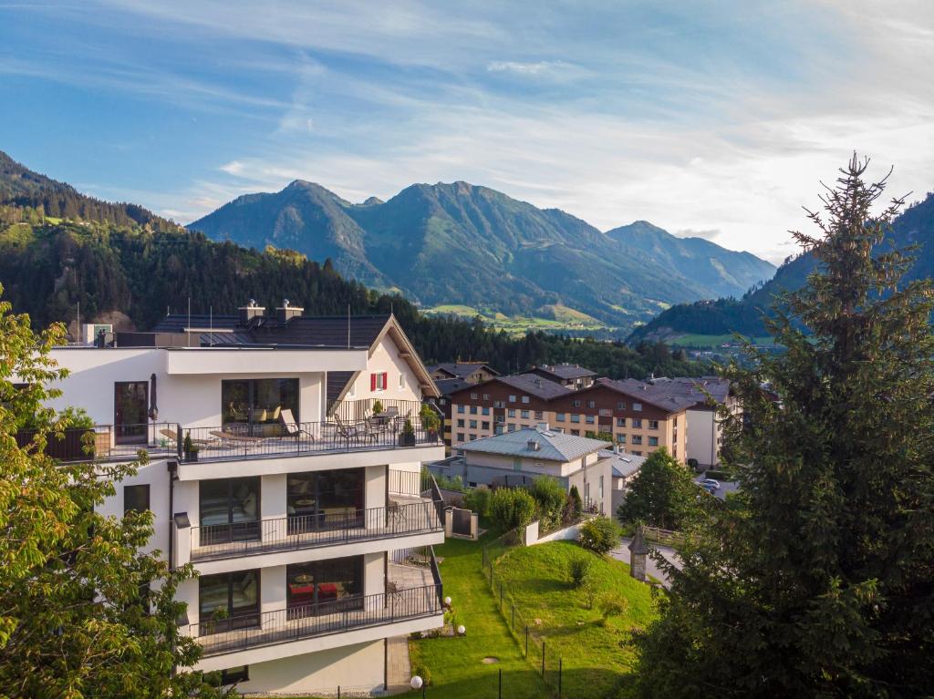 un edificio con balcones y montañas en el fondo en Freiraum 9 Living Apartment, en Sankt Johann im Pongau