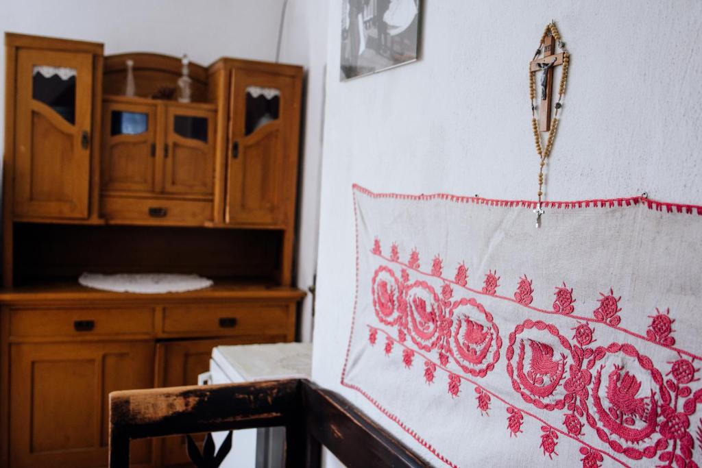 a room with a wooden cabinet and a table with a pillow at Onodilak Vendégház in Bîrzava