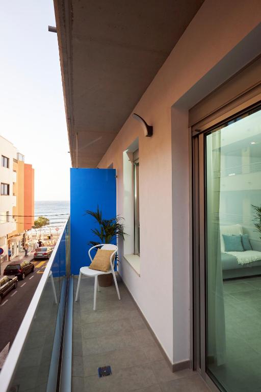 balkon z krzesłem i widokiem na ocean w obiekcie Medano Suites II w mieście El Médano