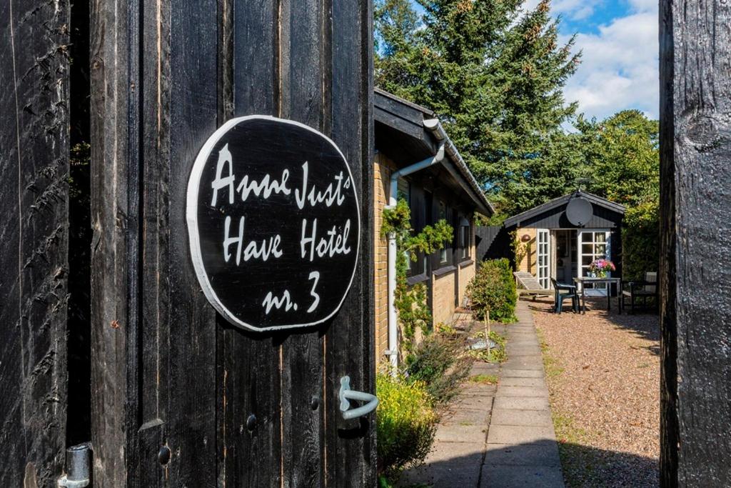 a sign on the side of a house with writing on it at Anne Just's Havehotel in Blokhus