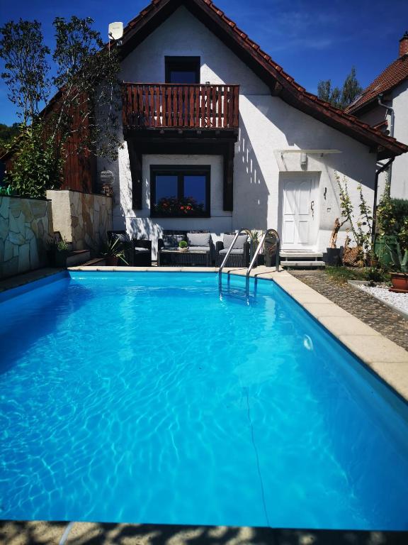 a blue swimming pool in front of a house at Ferienhaus Elsa in Kranichfeld