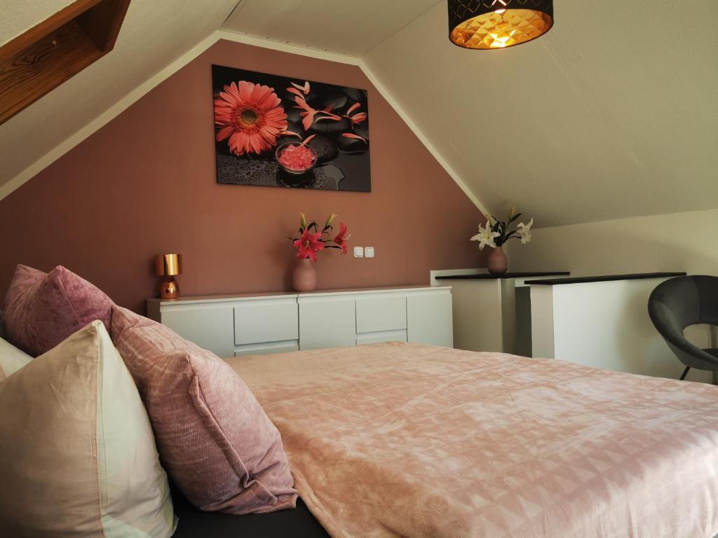 Ferienhaus Elsa في Kranichfeld: غرفة نوم مع سرير وورود على الحائط