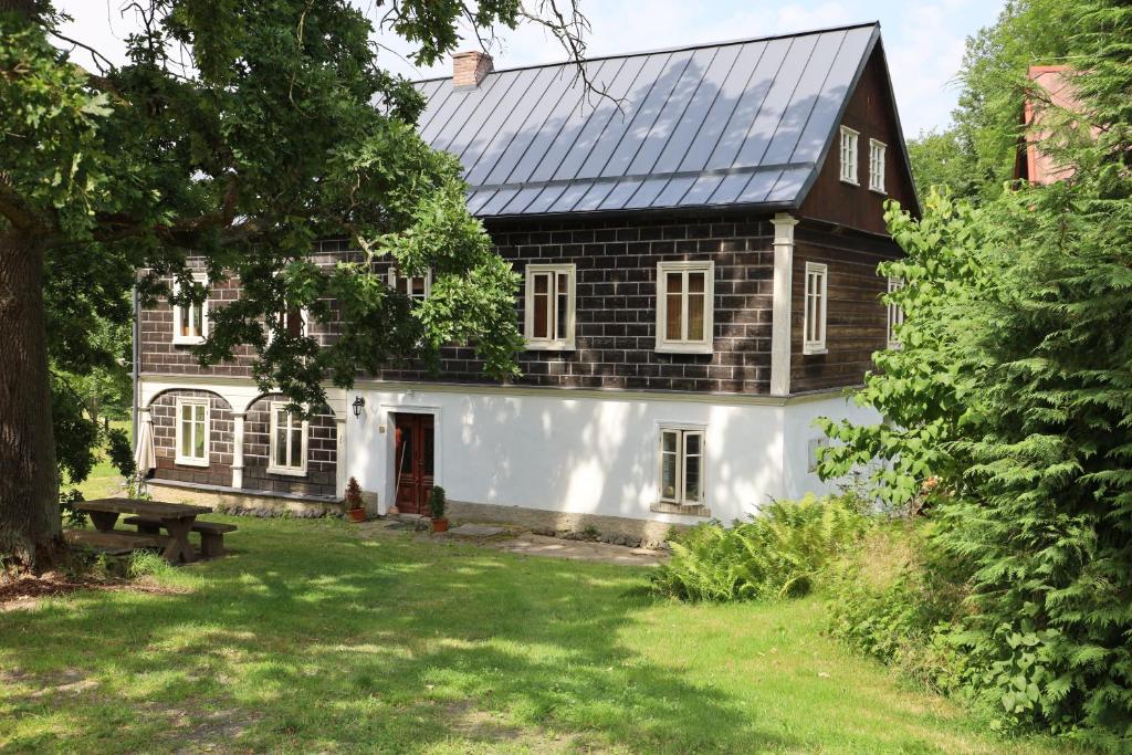 ein großes schwarzweißes Haus mit einem Hof in der Unterkunft Chalupa Huníkov in Huníkov