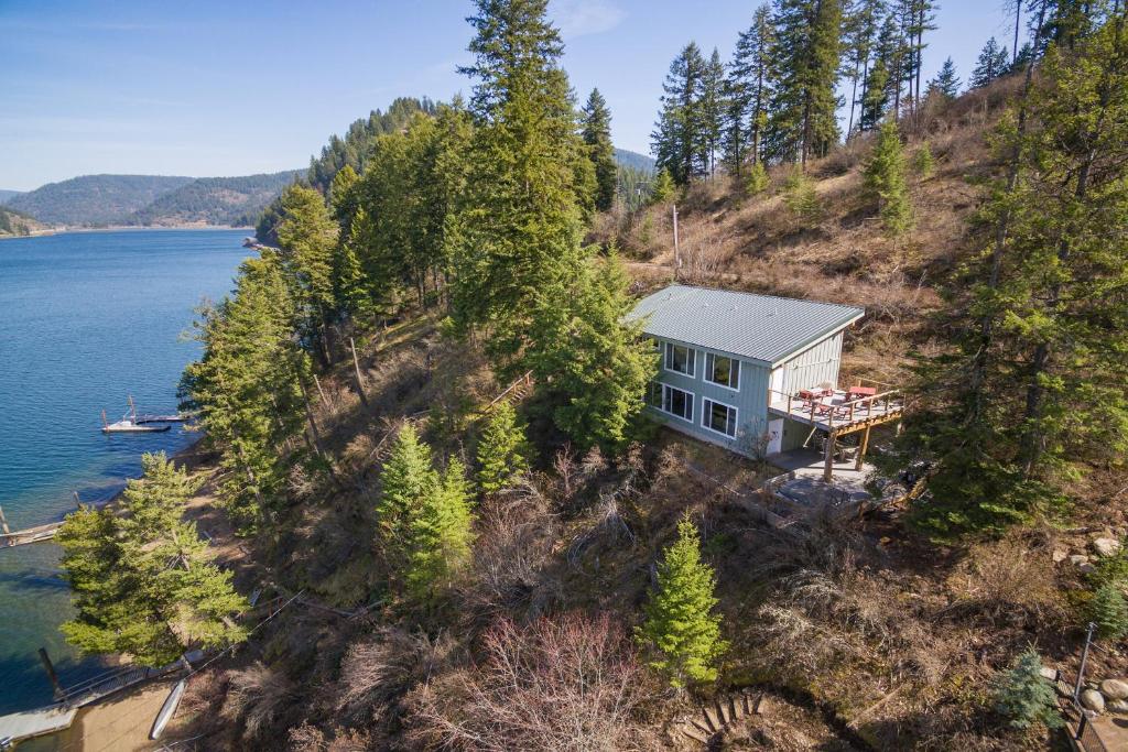 an aerial view of a house on a hill next to the water at Two Lakefront Homes - Main Home & Private Floating Home in Harrison
