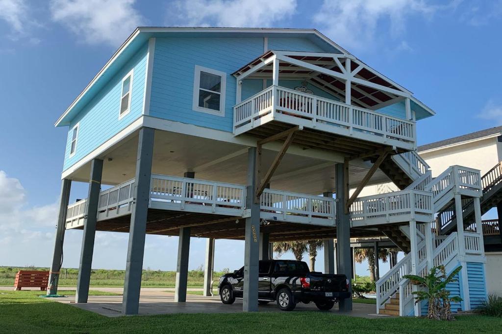 una casa blu con balconi e un camion parcheggiato di fronte di O' What A View a Gilchrist