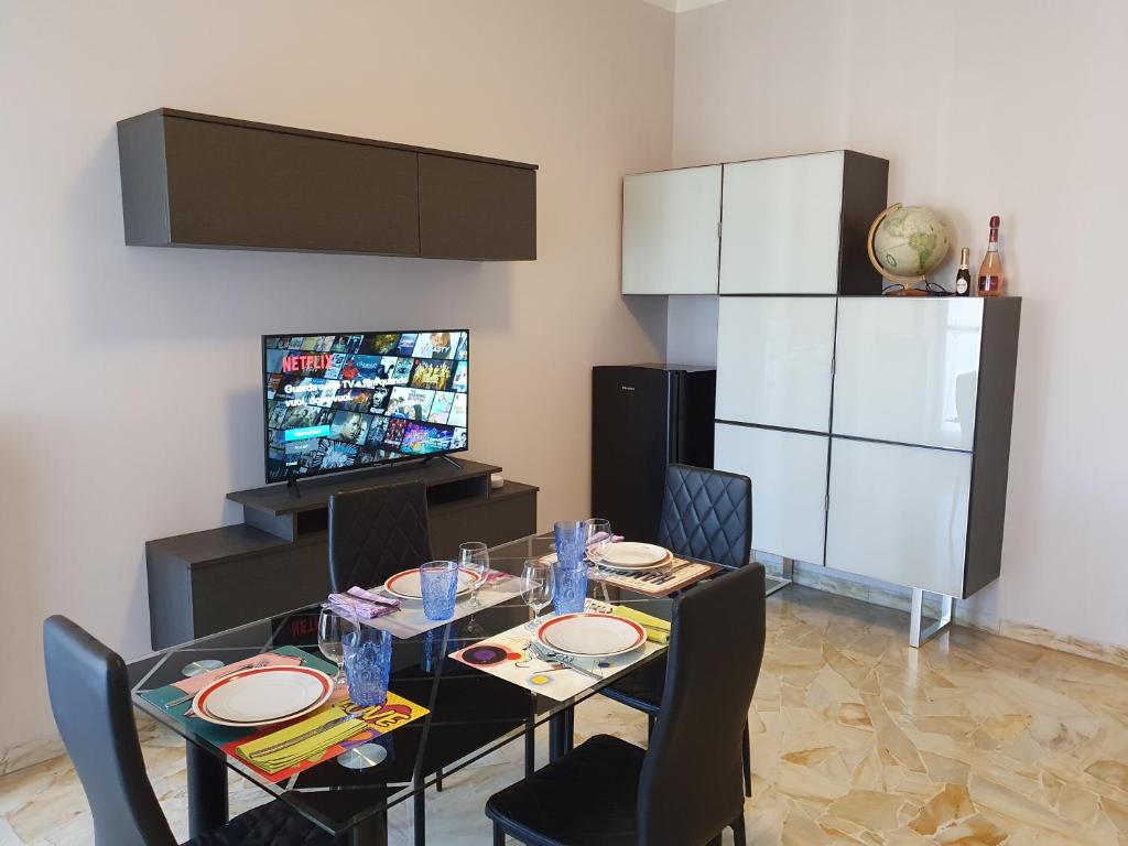 a dining room with a table and chairs and a television at Giolitti Luxury Apartment in Cuneo