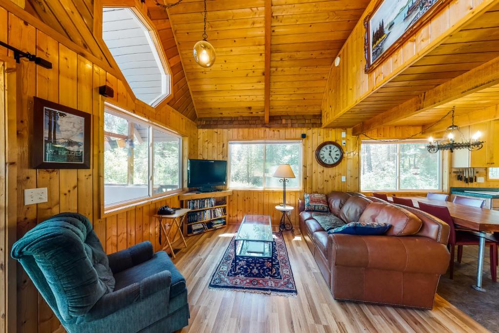 a living room with leather furniture and a dining room at Cabin In The Woods in Leavenworth