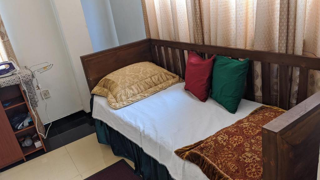 a small bedroom with a bed with two pillows at Cottage Home Belihuloya in Balangoda