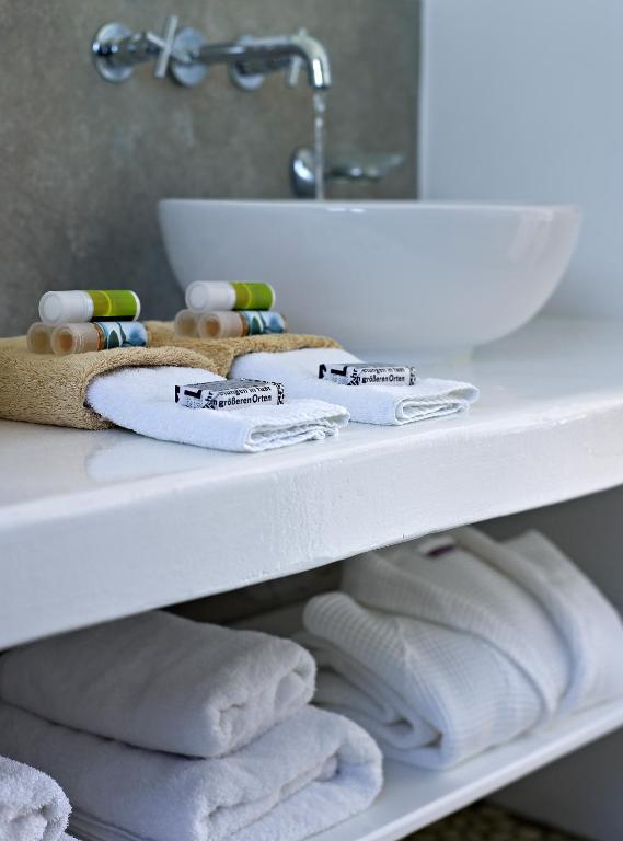 a shelf with towels and a sink in a bathroom at Santa Maria Luxury Suites & Spa in Adamas