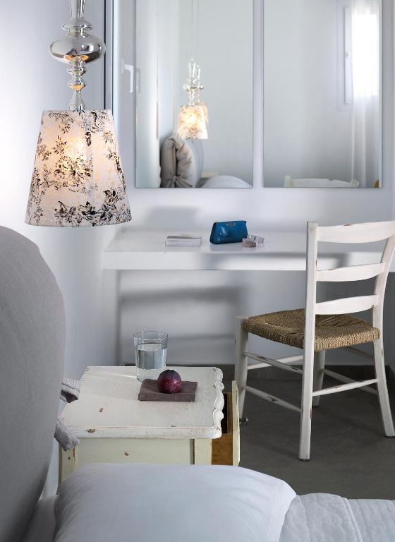 a bedroom with a desk and a chair and a lamp at Santa Maria Luxury Suites & Spa in Adamas