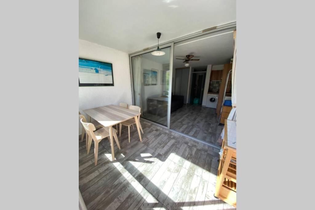 une salle à manger avec une table et une porte en verre dans l'établissement Spacieux studio sur le port de hyeres, à Hyères
