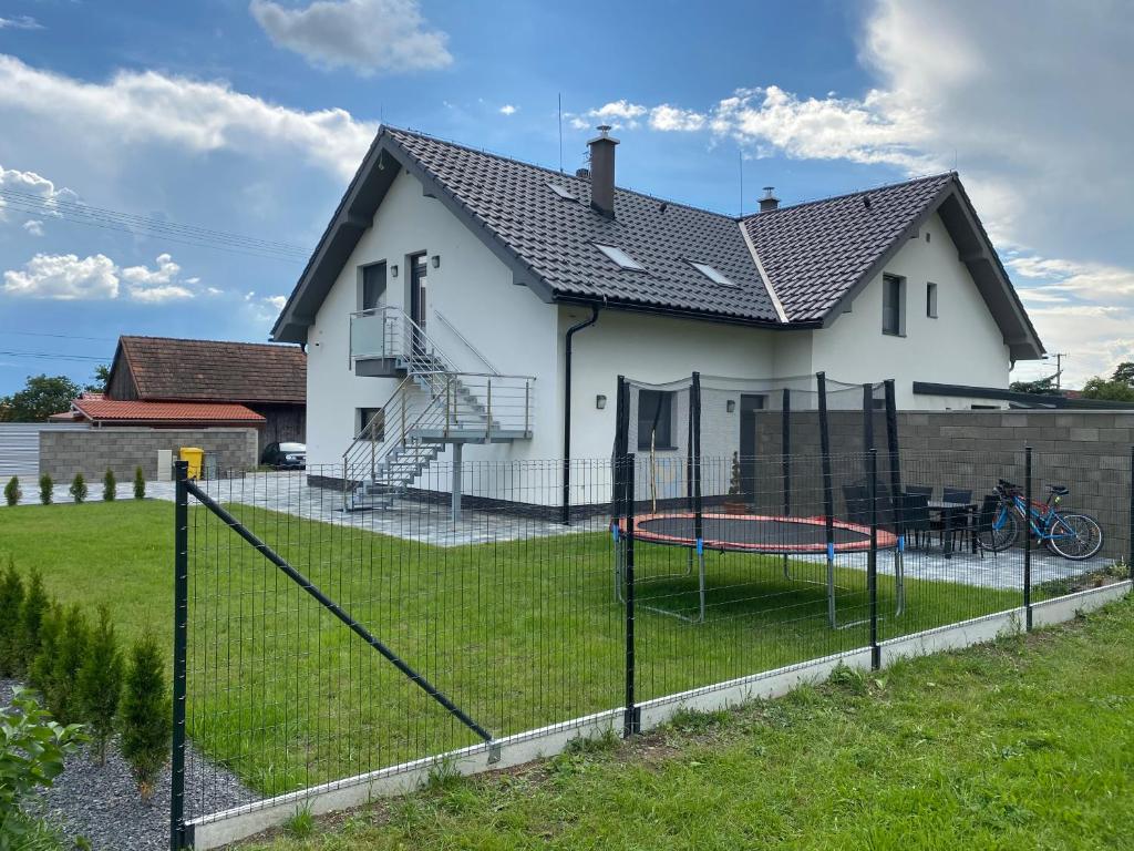 a white house with a playground in the yard at Apartmán Liso in Bobrovec