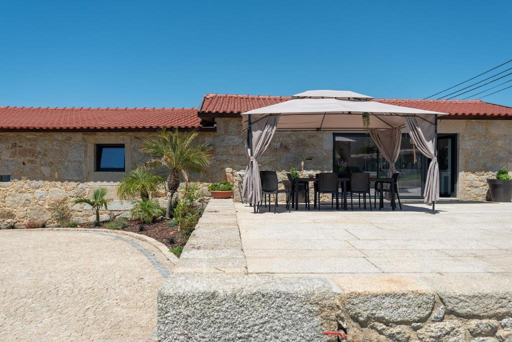 een patio met een tafel en een parasol bij Casinha da Eira in Esposende