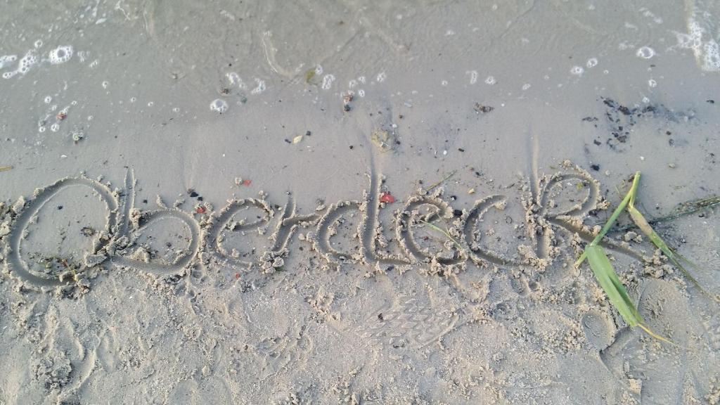 un mot écrit dans le sable sur la plage dans l'établissement FeWo Oberdeck Ueckermünde, à Ueckermünde