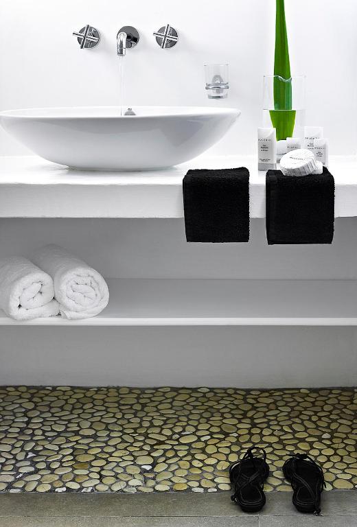 a bathroom with a sink and two towels at Santa Maria Luxury Suites & Spa in Adamas