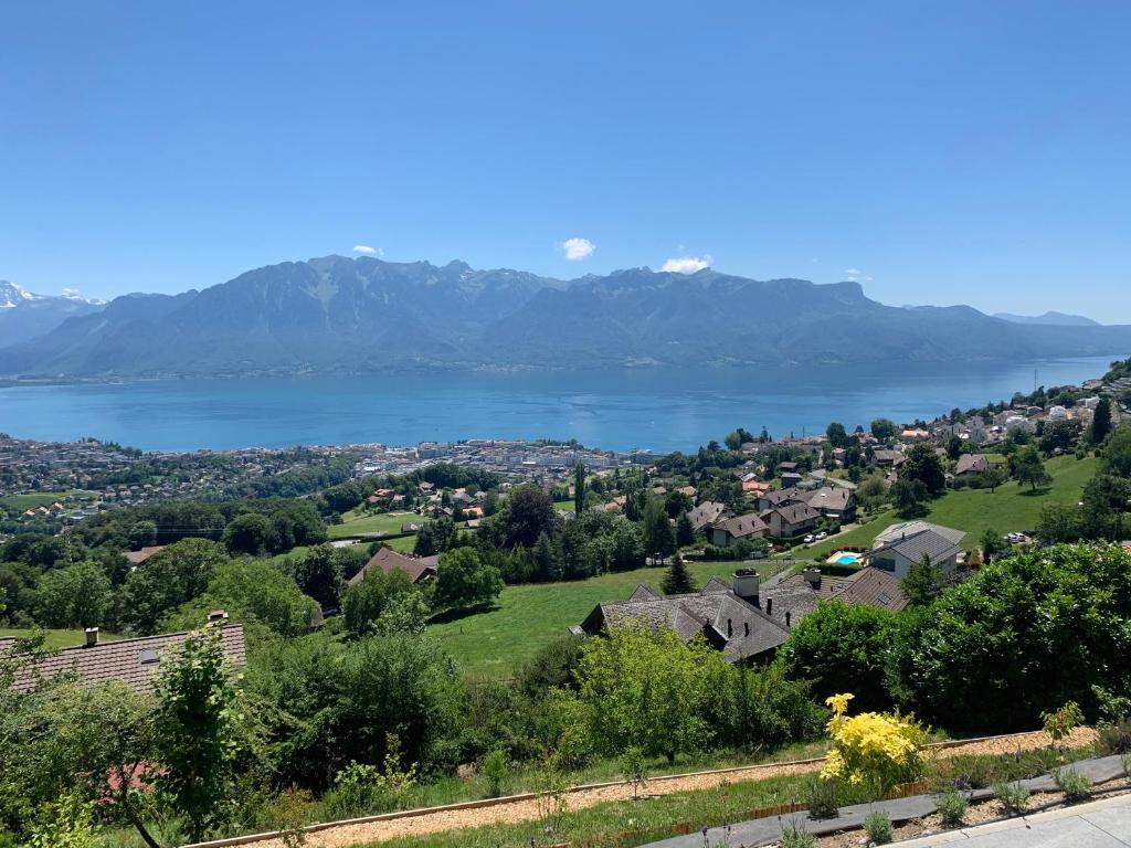 a view of a town with a lake and mountains at Appartement 180 degrés de rêve à Jongny in Jongny