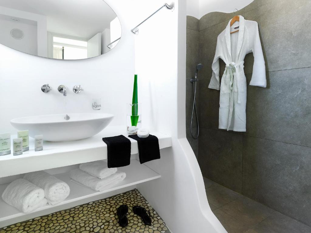 a white bathroom with a sink and a mirror at Santa Maria Luxury Suites & Spa in Adamas