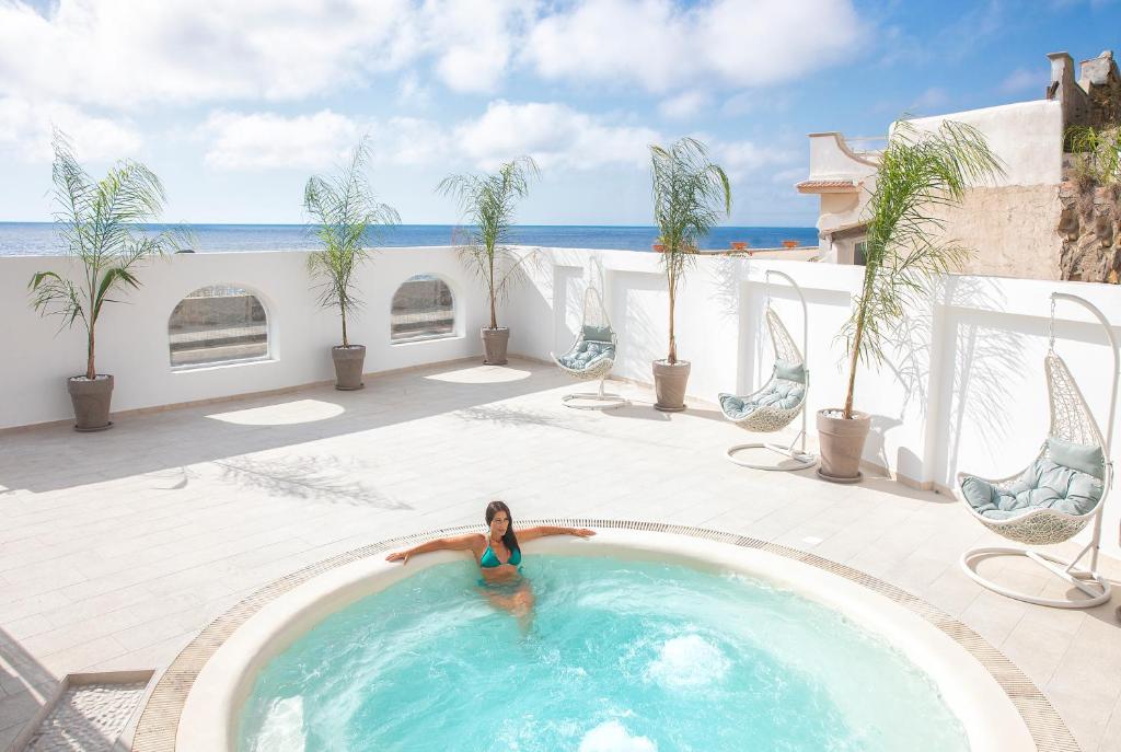 une femme dans une piscine sur une terrasse dans l'établissement Royal Sunset Hotel, à Ischia