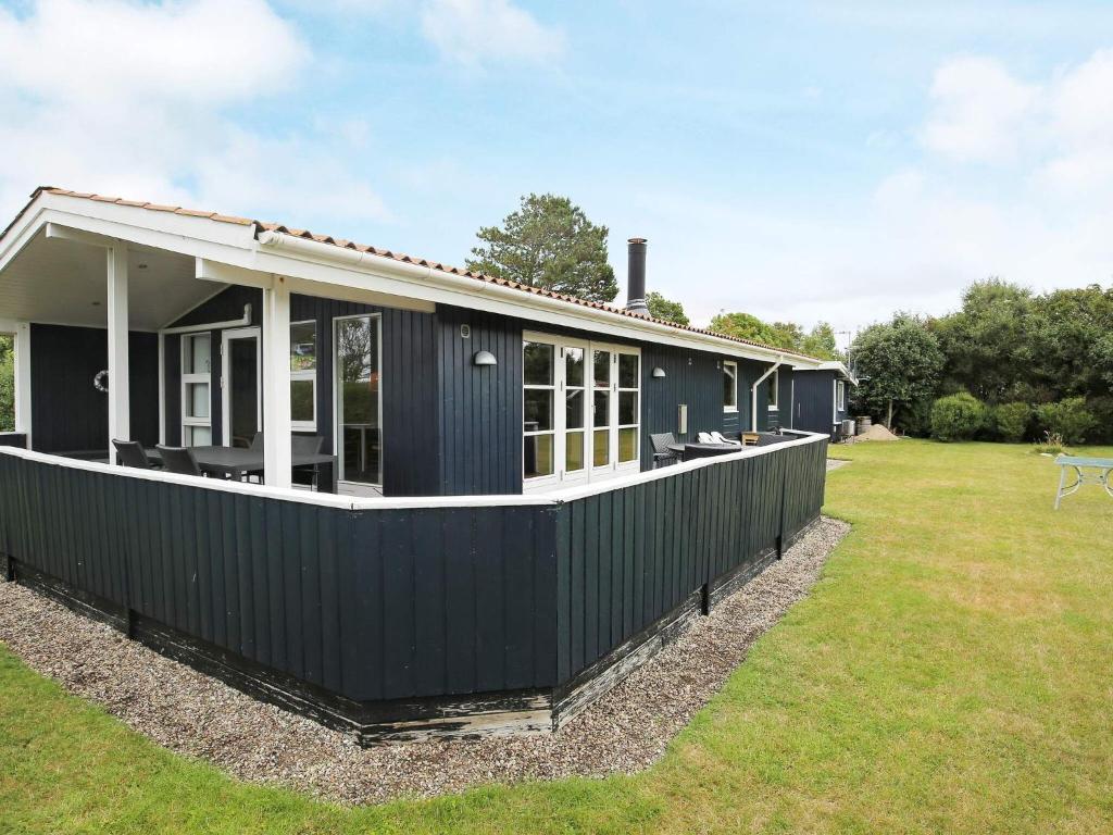 una casa negra en un patio con un campo de hierba en 6 person holiday home in Slagelse, en Slagelse
