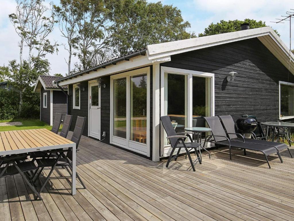 a house with a deck with a table and chairs at 6 person holiday home in Slagelse in Slagelse