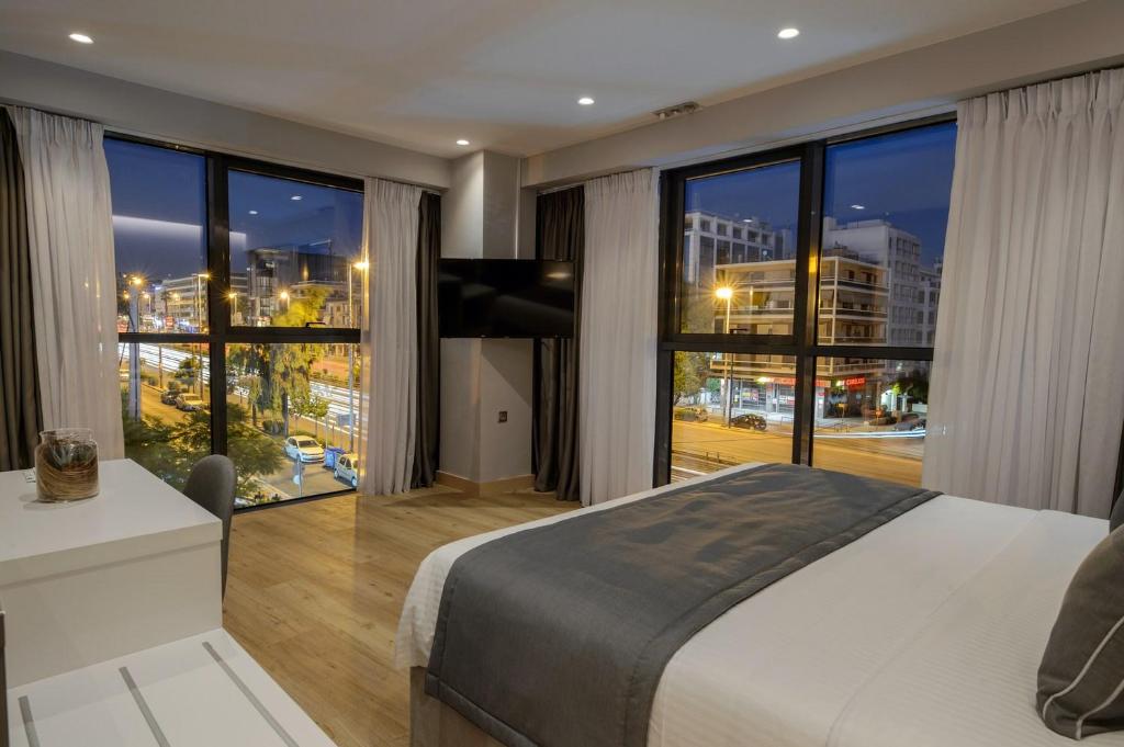 アテネにあるThe Convo Syngrou Apartmentsの大きなベッドと大きな窓のある寝室