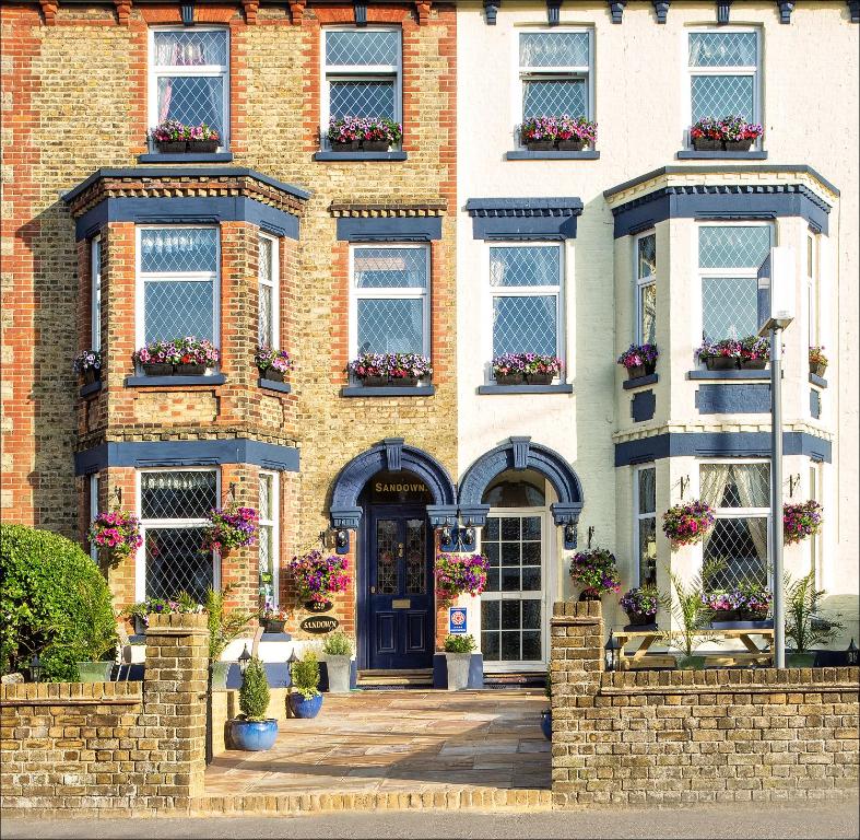 uma casa de tijolos com uma porta azul e janelas em Sandown & The Annexe em Dover