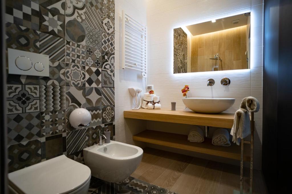 łazienka z umywalką, toaletą i lustrem w obiekcie L' Angolo dei poeti - Bed and Breakfast w mieście Bari