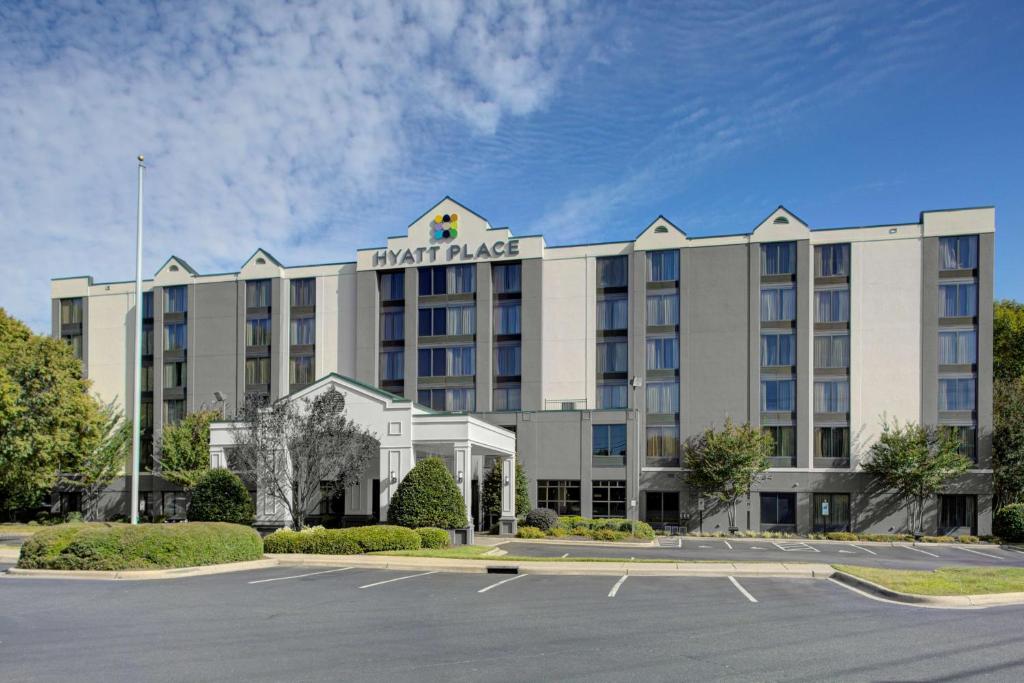 un hotel con un estacionamiento delante de él en Hyatt Place Charlotte Airport Billy Graham Parkway, en Charlotte