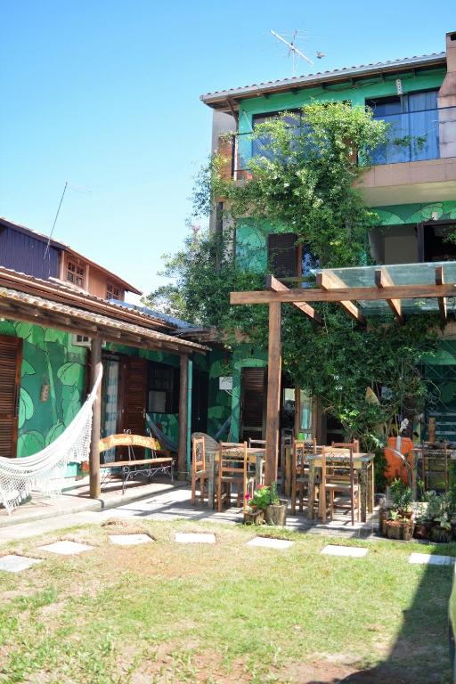a house with a hammock outside of it at Amarelo Hibisco in Guarda do Embaú