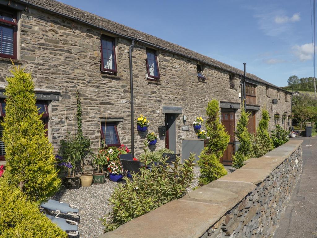 a stone building with plants in front of it at The Studio Malt Kiln Cottages in Grizebeck