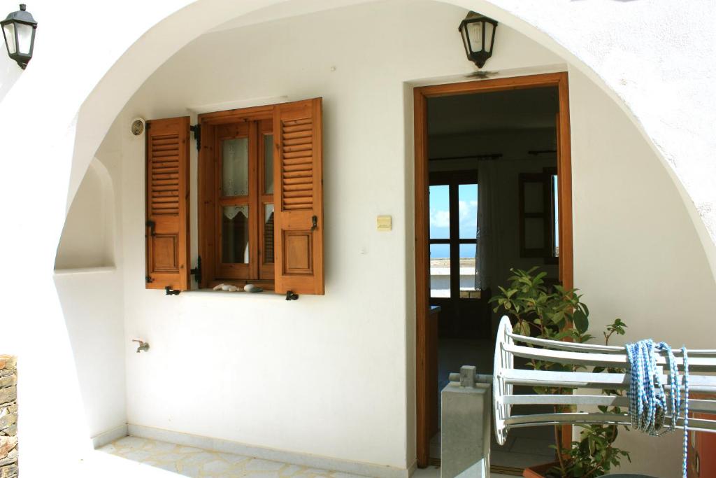 uma porta para uma casa com uma janela e um banco em Matina - Stavros Traditional Houses em Kóronos