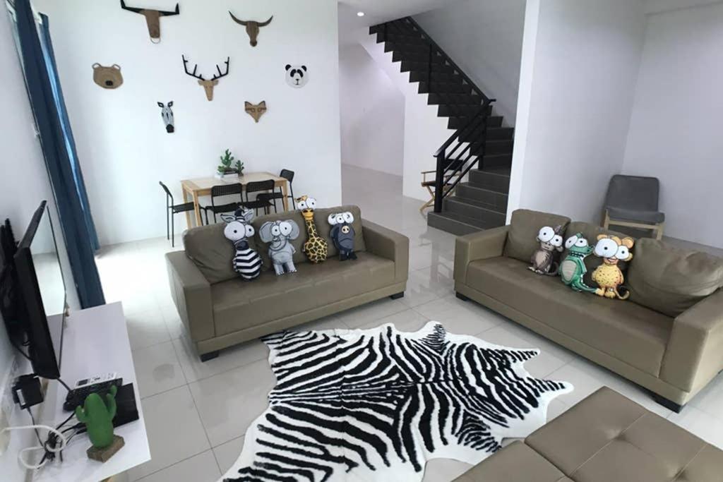 a living room with two couches and a zebra rug at be.Animania -8-10mins Lost World Tambun -14-18pax in Ipoh