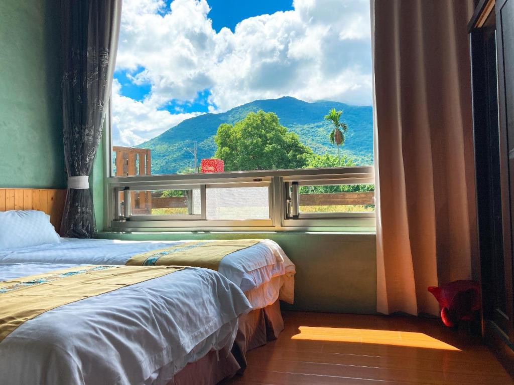 1 dormitorio con ventana y vistas a la montaña en Ying Tian Ye Homestay, en Jian