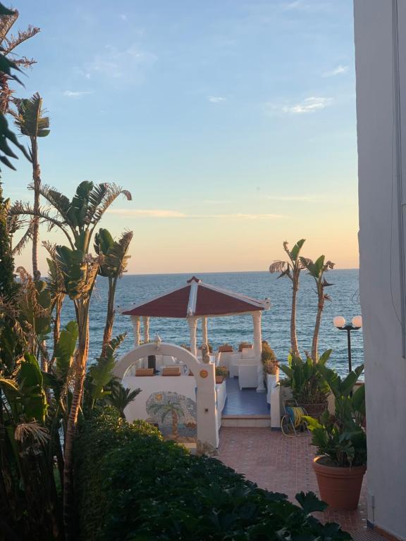 a gazebo on the beach with the ocean in the background at Appartamenti Tina in Villa Restituta in Ischia