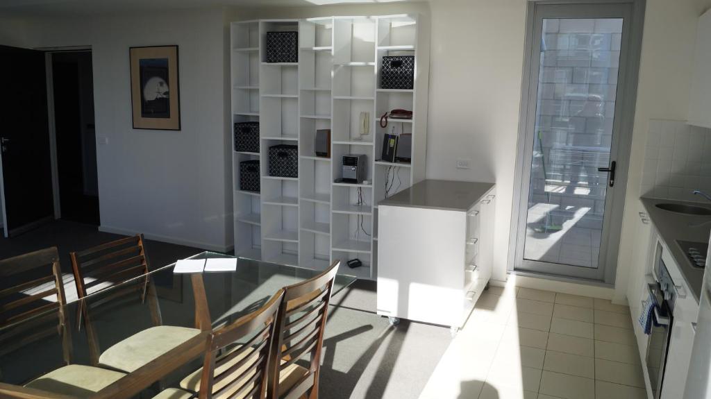 Un comedor con una mesa de cristal y sillas. en Canberra CBD Metropolitan, en Canberra