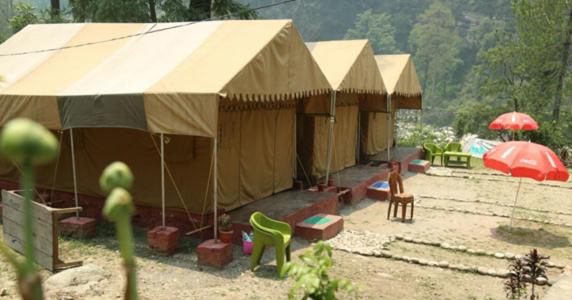 a group of tents with chairs and umbrellas at Toorani Camps in Uttarkāshi