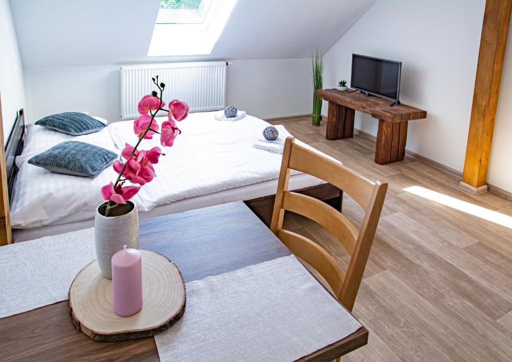 Pokój z łóżkiem i stołem ze świecą w obiekcie Apartmány Kurojedy w mieście Bor