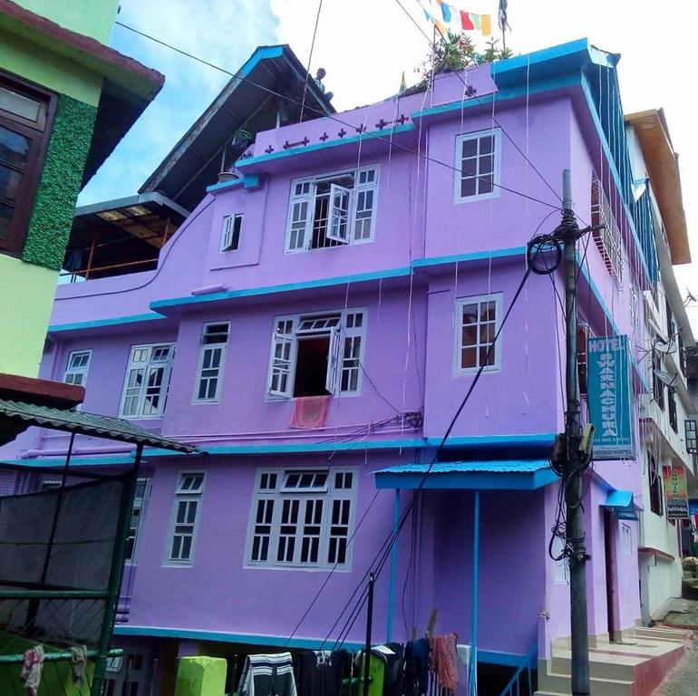 un bâtiment violet au milieu d'une rue dans l'établissement Very Homely Hotel for Tourists, à Gangtok