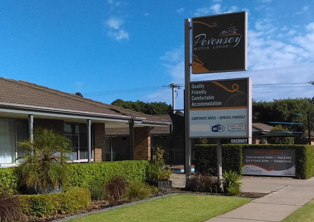 un cartello di fronte a una casa di Pevensey Motor Lodge a Echuca