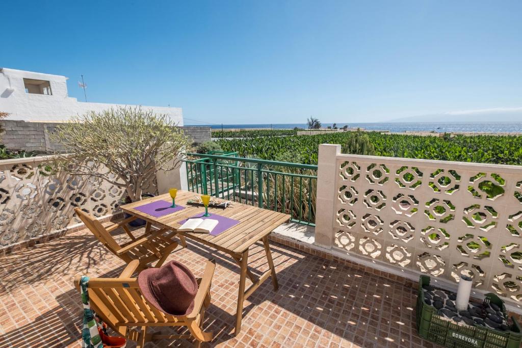 un patio con mesa, sillas y el océano en Casa Tabaiba - Villa Perenquén, en Guía de Isora