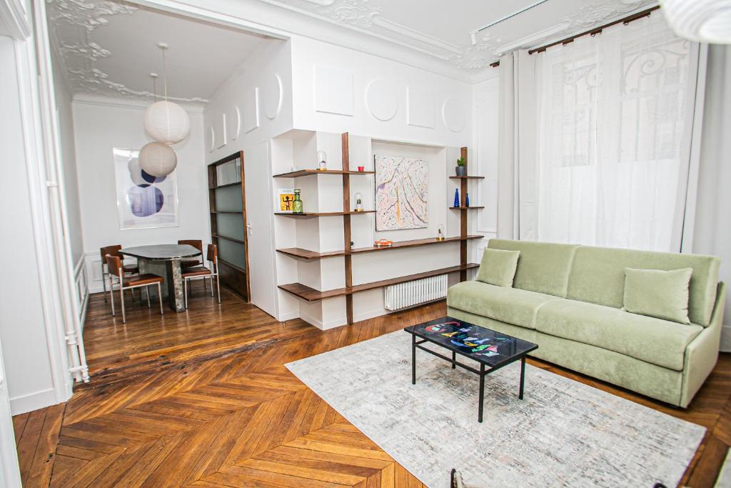 un salon avec un canapé et une table dans l'établissement Joie Paris Arc de Triomphe - Champs Elysée, à Paris