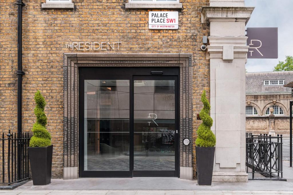 un edificio de ladrillo con una puerta con un cartel. en The Resident Victoria, en Londres