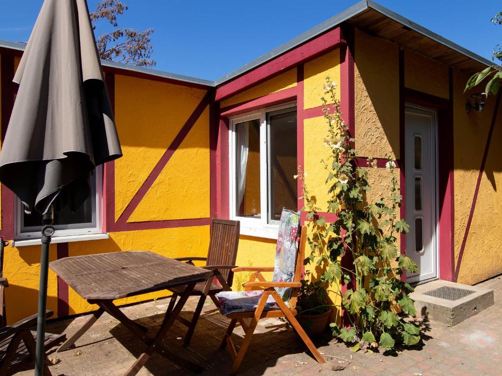 an umbrella and a chair next to a colorful house at Ferienhaus mit maritimer Einrichtung in Kröslin