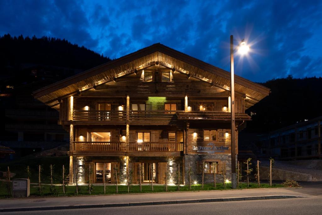 a large wooden building with a street light in front of it at LA FERME D'ARTHUR in Le Grand-Bornand