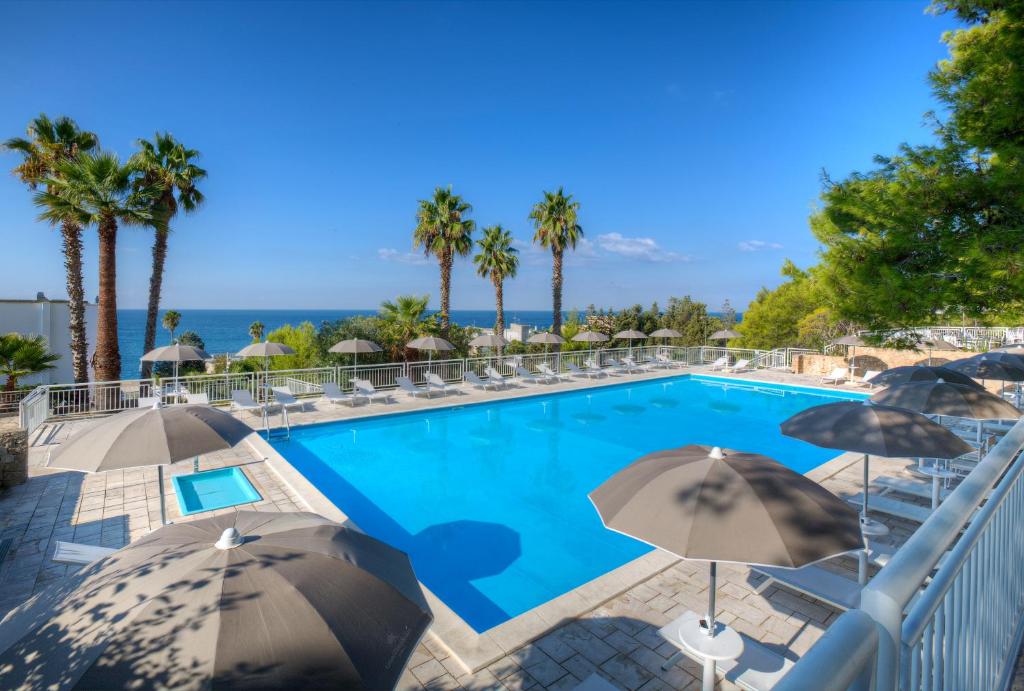 una piscina con ombrelloni e l'oceano di Grand Hotel Riviera - CDSHotels a Santa Maria al Bagno