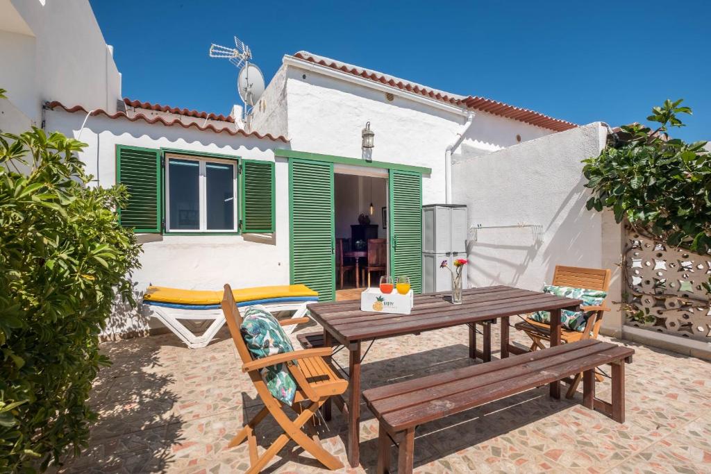 eine Terrasse mit einem Holztisch und Stühlen vor einem Haus in der Unterkunft Casa Cardón - Villa Perenquén in Guía de Isora