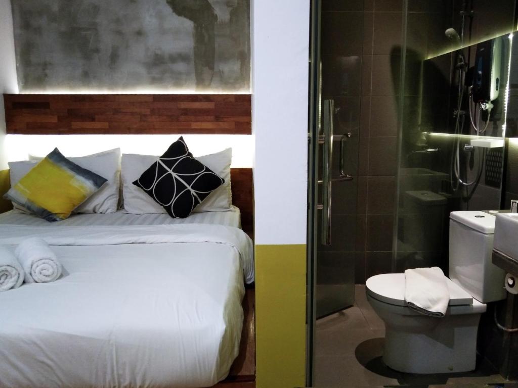 a bedroom with a bed and a shower and a toilet at Chaos Boutique Hotel Kuala Lumpur in Kuala Lumpur