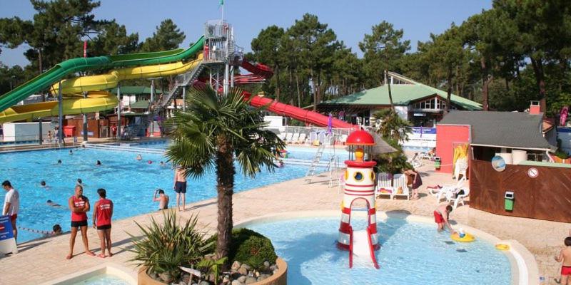 a large pool with a water park with people in it at Camping la Palmyre in Les Mathes