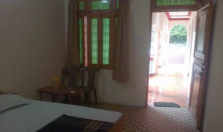 sypialnia z łóżkiem i drzwiami do korytarza w obiekcie Hotel Om Shiv Shankar w mieście Uttarkāshi